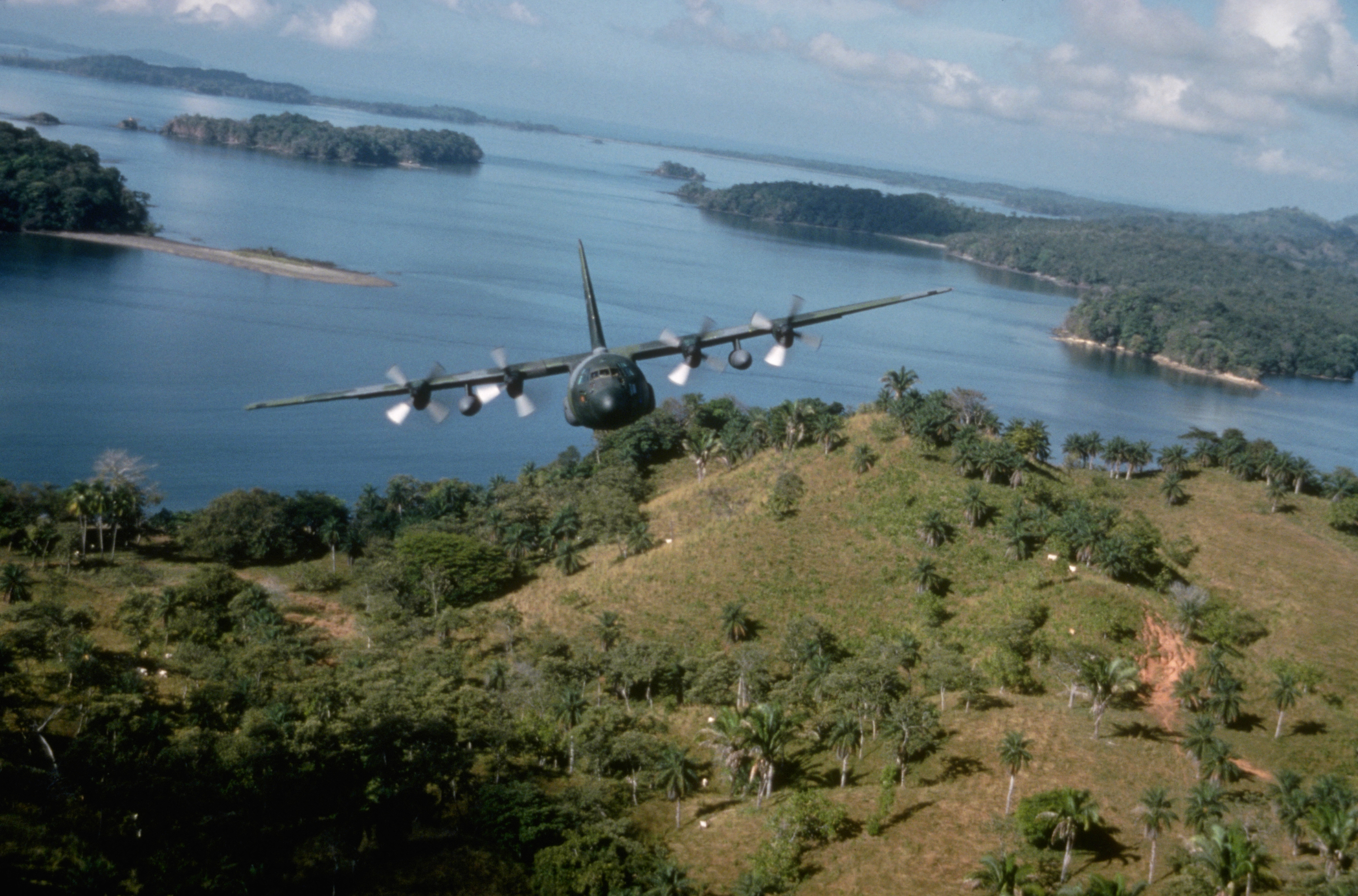 Un avion C-130E Hercules du 934th Tactical Airlift Group, US Air Force Reserve, survole la côte tout en retournant à la base aérienne Howard, au Panama, pendant l'opération Just Cause. Janvier 1990. (Photo de © CORBIS/Corbis via Getty Images)