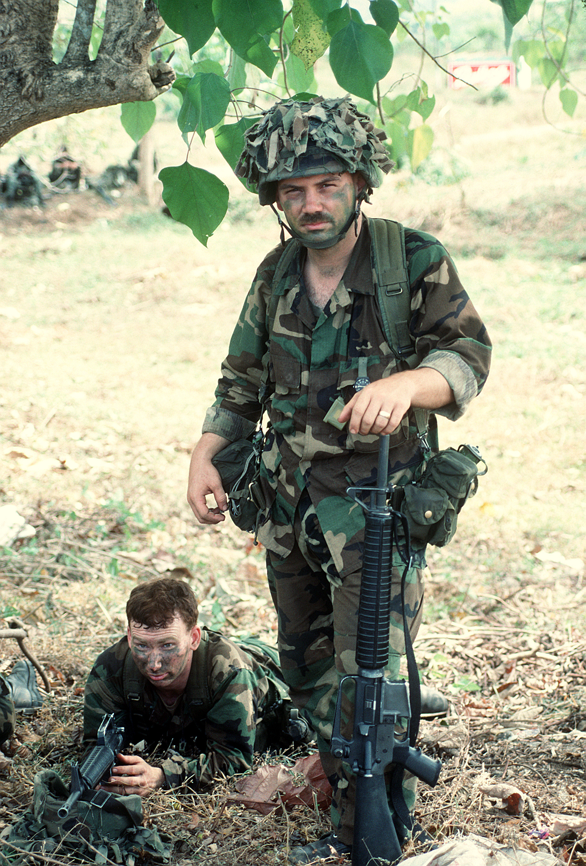 Deux membres de la 7e Division d'infanterie font une pause lors d'une patrouille lors de l'opération Just Cause. Les soldats sont armés de fusils M-16A2.