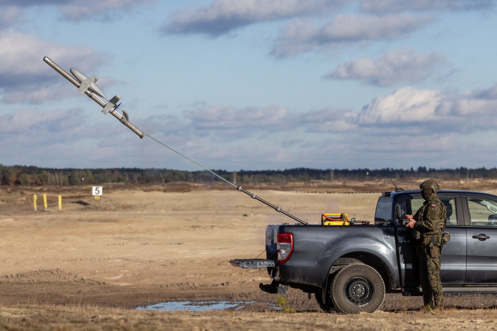 TOPSHOT - Un soldat polonais est vu alors qu'il pilote un drone d'interception du système de contre-drone américain MEROPS lors d'essais sur le terrain d'entraînement militaire de Nowa Deba, dans le sud-est de la Pologne, le 18 novembre 2025. (Photo de Wojtek RADWANSKI / AFP) (Photo de WOJTEK RADWANSKI/AFP via Getty Images)