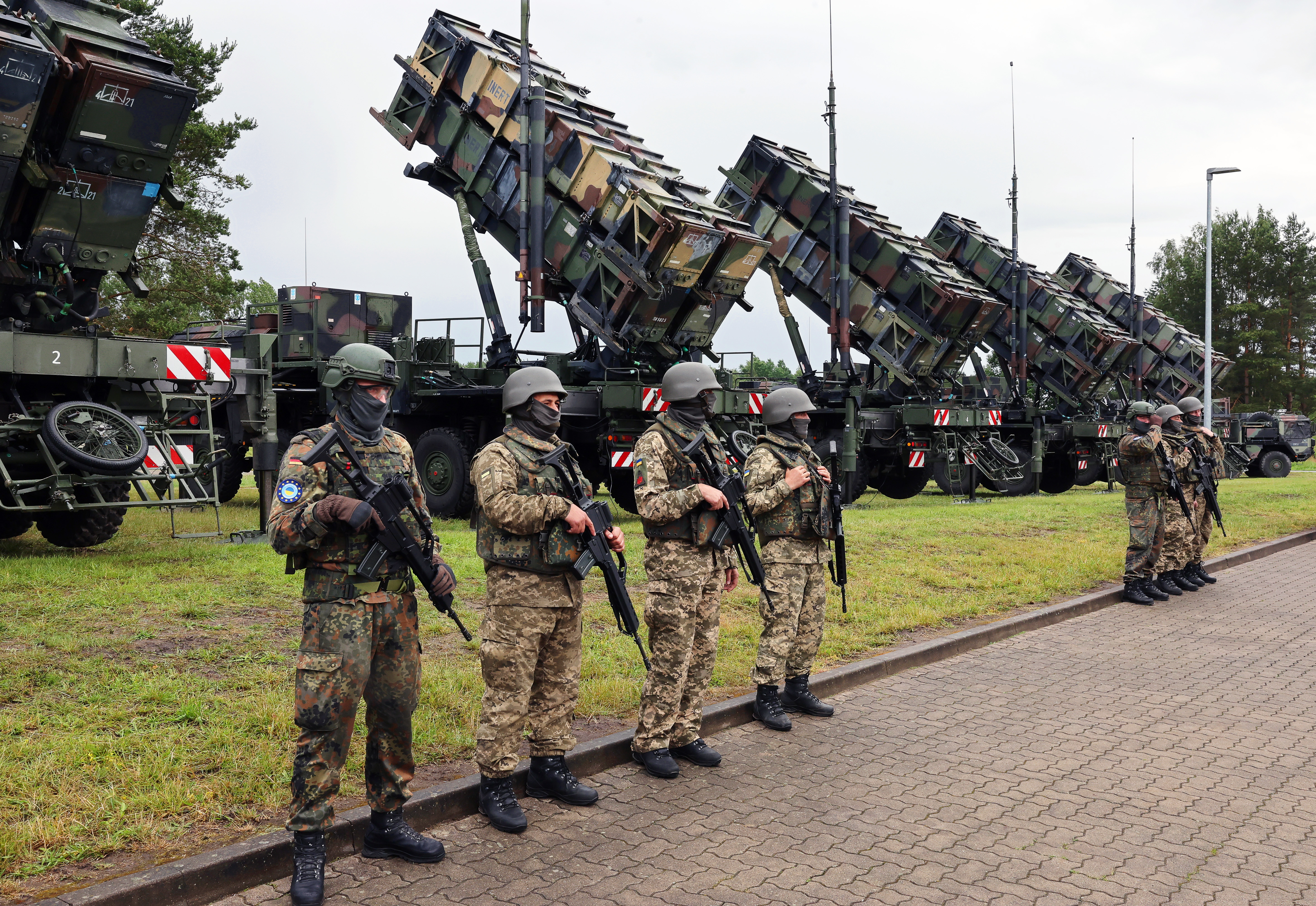 11 juin 2024, Mecklembourg-Poméranie occidentale, --- : des soldats allemands et ukrainiens se tiennent devant des systèmes de missiles anti-aériens « Patriot » lors de la visite du président ukrainien Zelenskyi dans une zone d