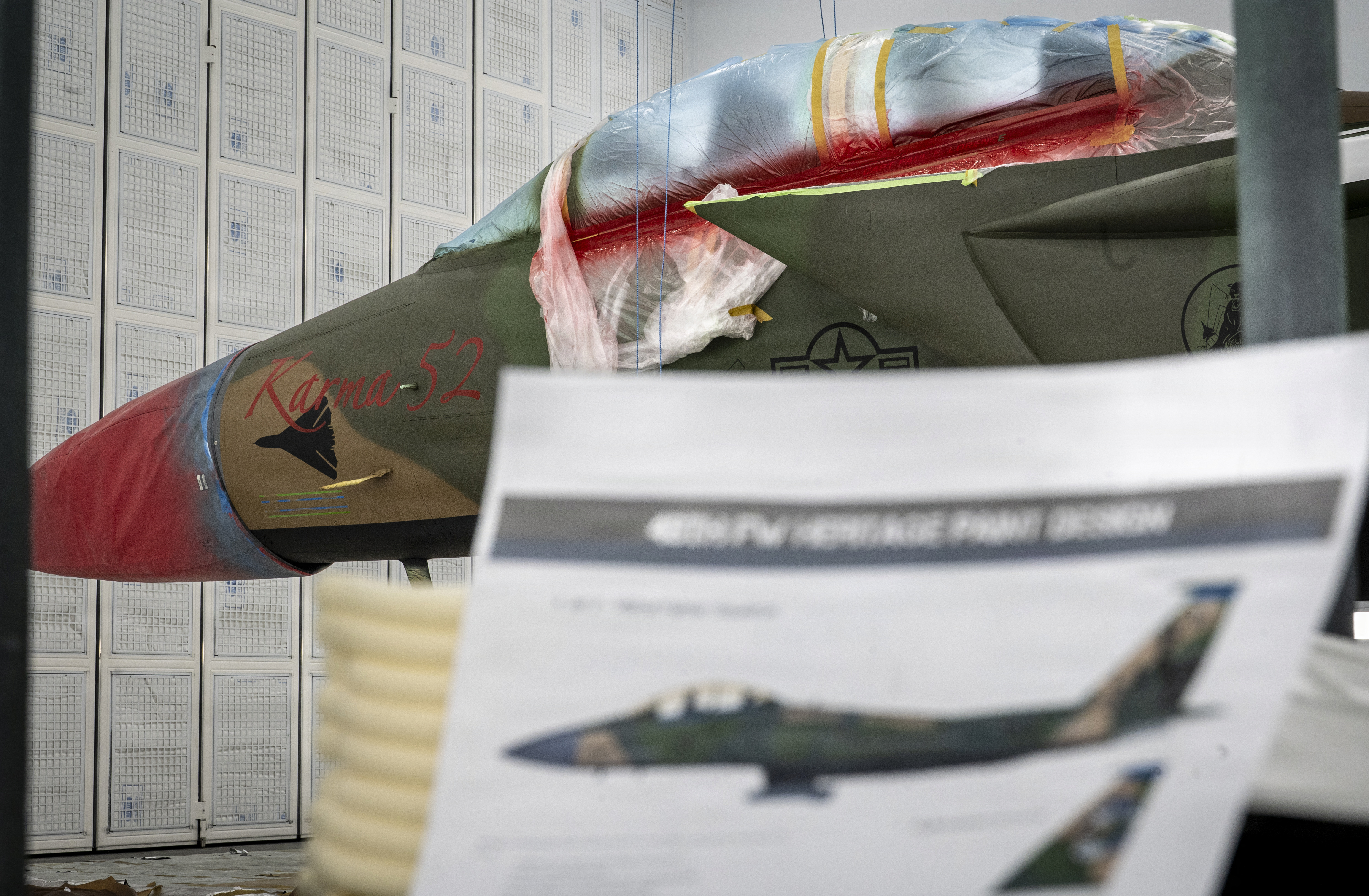 Un avion F-15E Strike Eagle de l'US Air Force affecté au 494e Escadron de génération de chasseurs se trouve derrière une maquette de conception patrimoniale à la RAF Lakenheath, en Angleterre, le 18 mars 2026. Au cours de l'opération El Dorado Canyon, un avion F-111F Aardvark « Karma 52 », le capitaine et l'officier du système d'armes ont disparu alors qu'ils survolaient la mer Méditerranée. Les marquages sur la peinture moderne rendent hommage au personnel et aux avions perdus au cours de la mission. (Photo de l'US Air Force par un membre de la 1re classe Rilynn Jacobs)