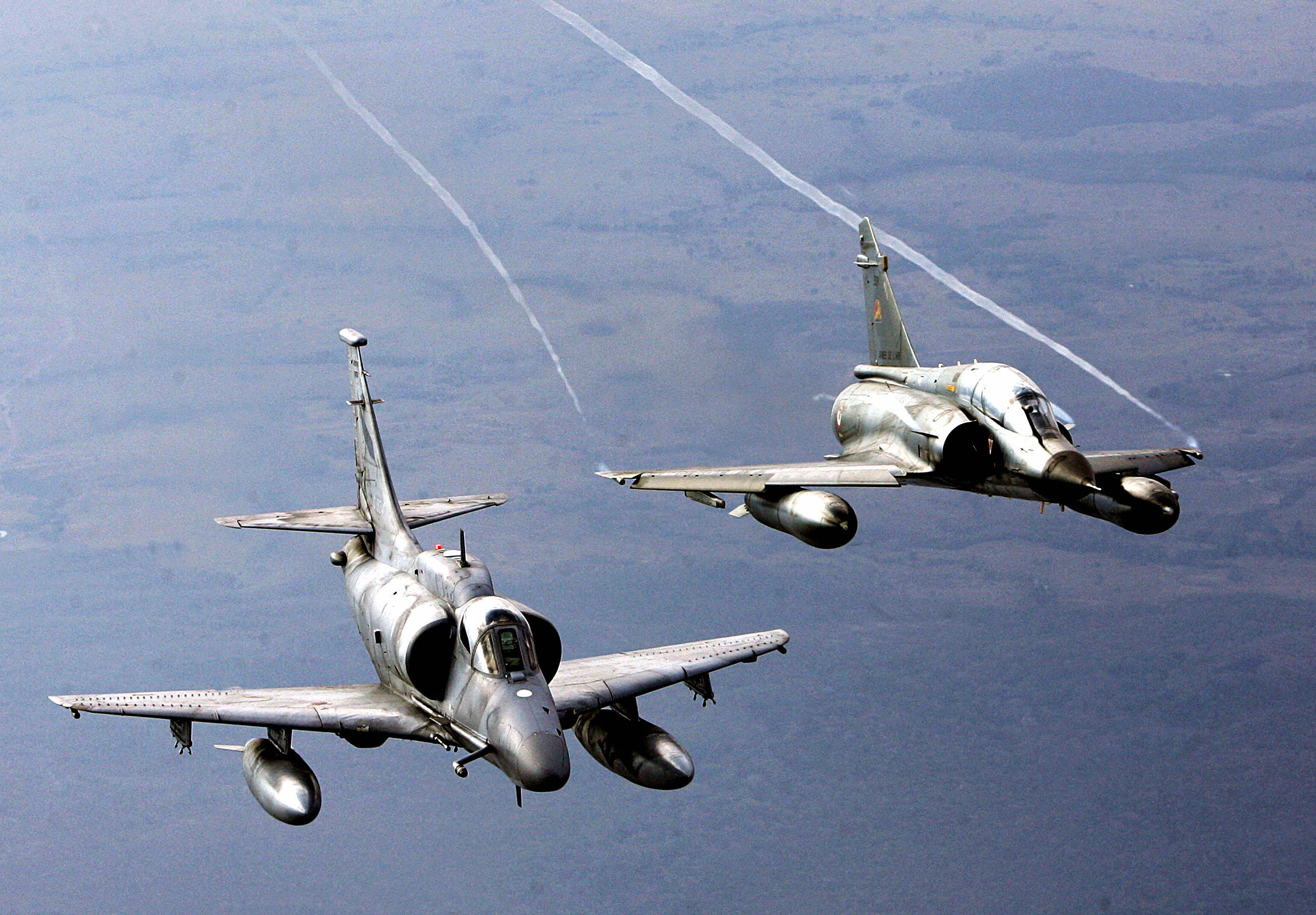 Brasilia, BRÉSIL : un avion A-4 Skyhawk de l'armée de l'air argentine (L) et un avion Mirage 2000 de l'armée de l'air française volent après avoir décollé de la base aérienne brésilienne d'Anapolis, à 170 km de Brasilia, le 25 août 2006, lors des manœuvres conjointes III Cruzeiro do Sul (Cruzex III) auxquelles participent le Brésil, la France, le Venezuela, le Chili, l'Argentine et l'Uruguay. Ces exercices aériens se heurtent à la possibilité d'agir dans le cadre de coalitions de l'ONU dans d'autres régions du globe. Au total, 61 avions et 1 309 personnes participeront au Cruzex III du 21 août au 1er septembre. AFP PHOTO/Evaristo SA (Le crédit photo doit se lire EVARISTO SA/AFP via Getty Images)