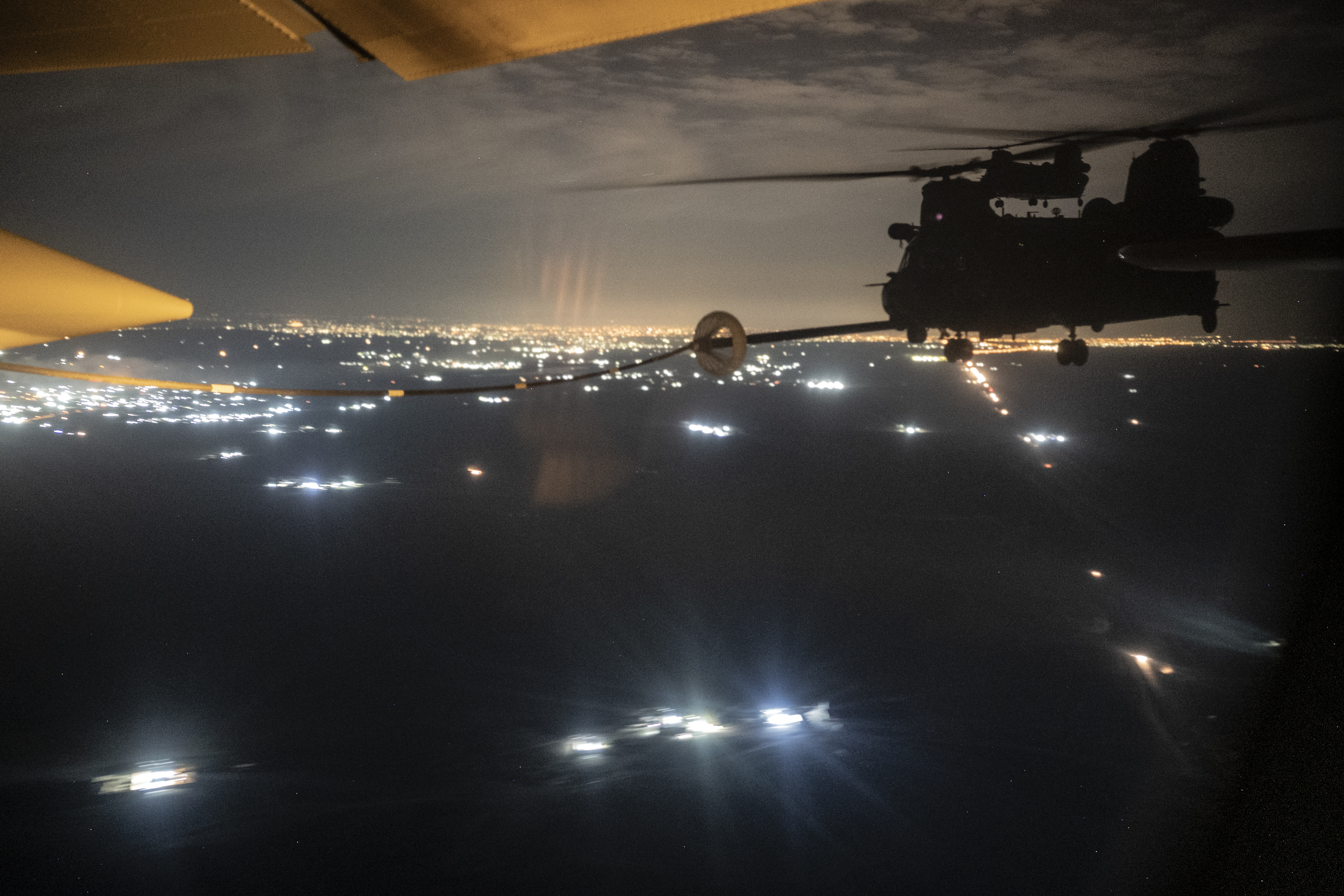 Deux Chinook MH-47G de l'armée américaine effectuent des opérations de ravitaillement en vol d'hélicoptères avec un HC-130J combat King II de l'US Air Force, affecté au 26e Escadron de sauvetage expéditionnaire, au-dessus d'un endroit non divulgué dans la zone de responsabilité du Commandement central des États-Unis, le 27 décembre 2022. Les actifs du Commandement central de l'US Air Force mènent régulièrement des opérations conjointes à l'appui des priorités de stabilité régionale du CENTCOM. (Photo de l'US Air Force par le sergent d'état-major Gerald R. Willis)