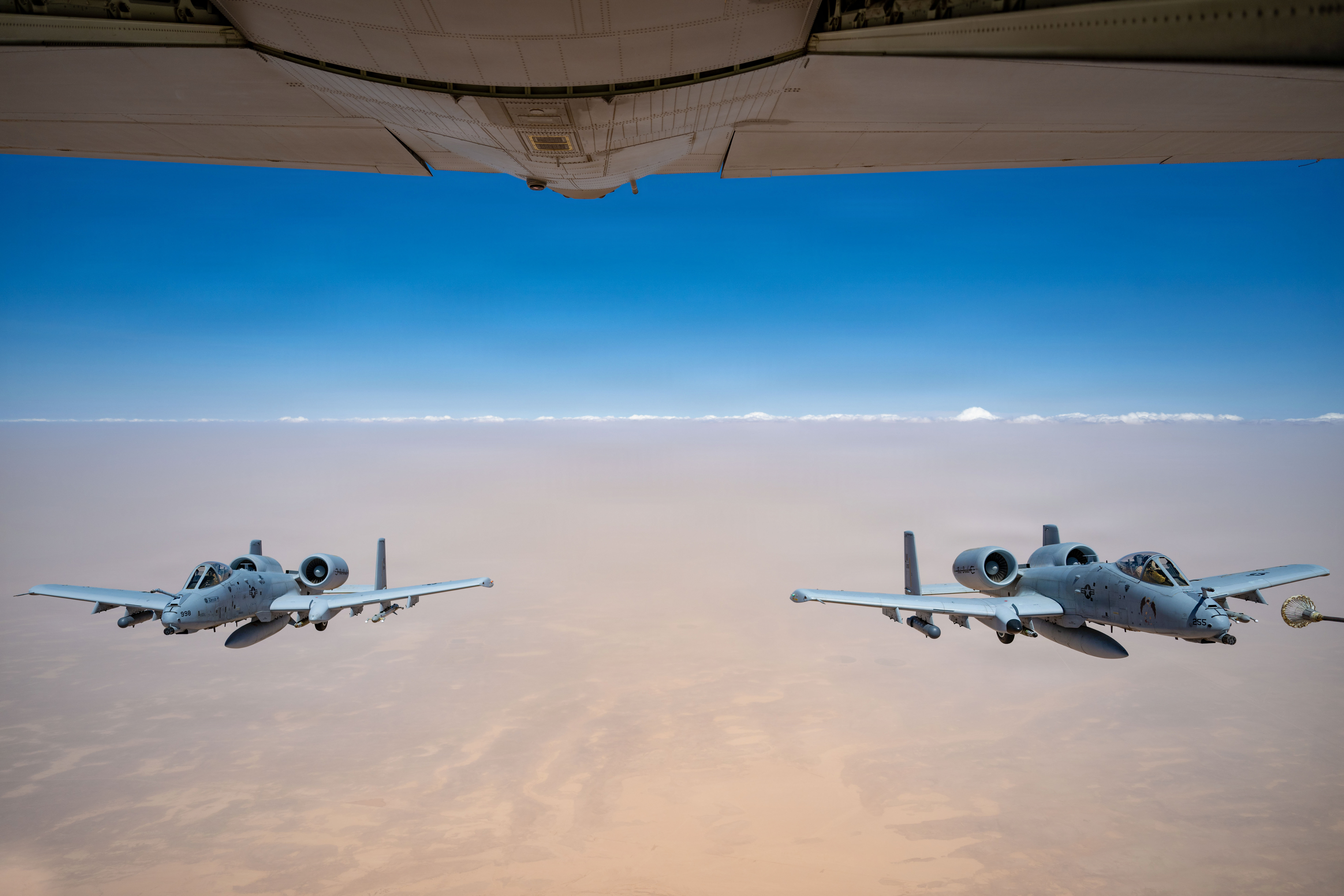 Deux avions A-10C Thunderbolt II de l'US Air Force s'approchent d'un avion HC-130J Combat King II pour le ravitaillement en vol dans la zone de responsabilité du Commandement central des États-Unis, le 9 mai 2026. (Photo de l'US Air Force)