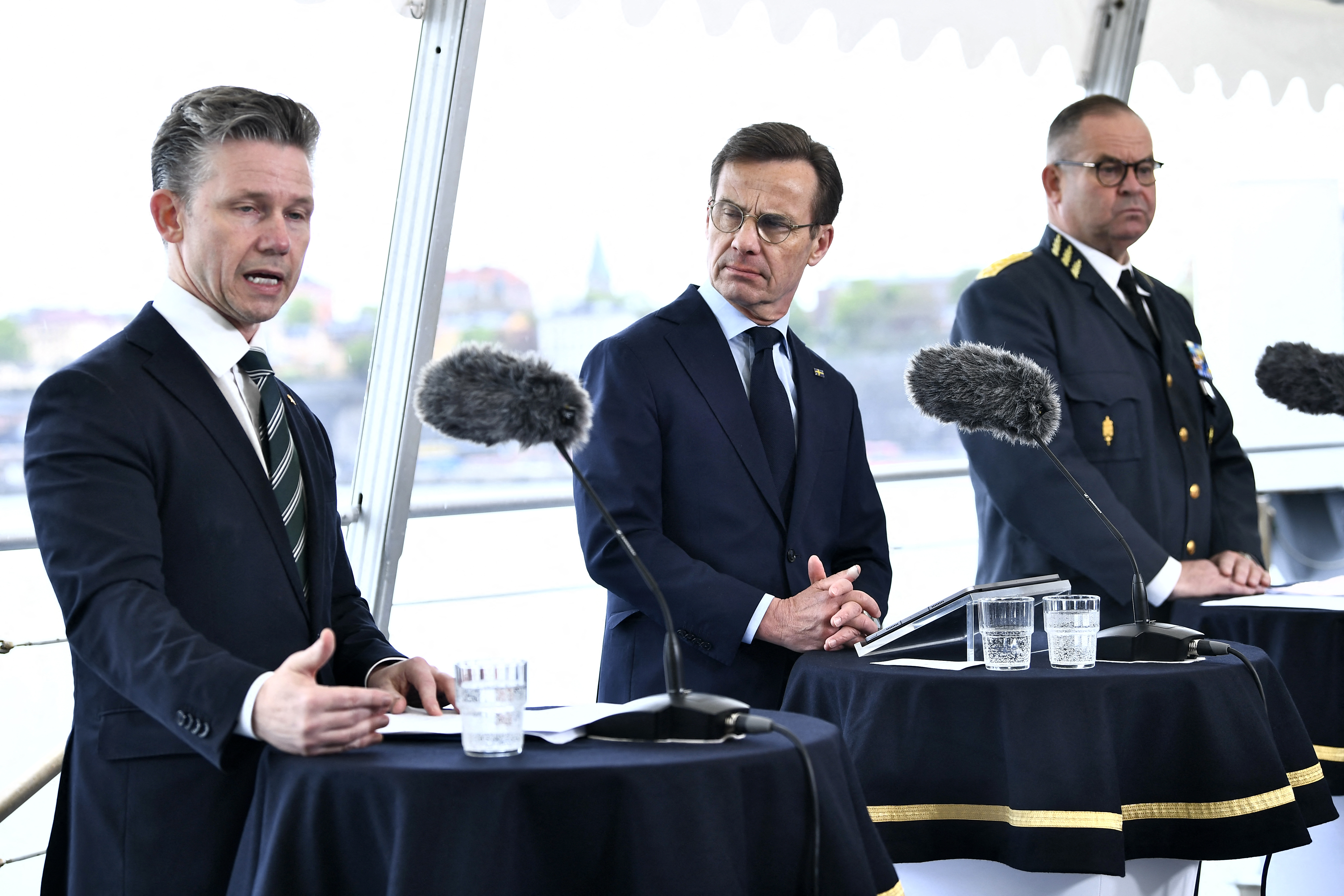Le ministre suédois de la Défense Paal Jonson, le Premier ministre suédois Ulf Kristersson et le chef d'état-major de la Défense suédois et commandant suprême Michael Claesson donnent une conférence de presse à bord de la corvette de classe Visby HMS Haernoesand à Stockholm, en Suède, le 19 mai 2026. La Suède va de l'avant avec le Groupe naval français alors que les forces armées se préparent à acquérir leurs navires de guerre les plus grands et les plus chers depuis des décennies. La Suède s'apprête à acheter quatre frégates de type FDI. (Photo de Lars SCHRODER / TT News Agency / AFP via Getty Images) / Suède OUT