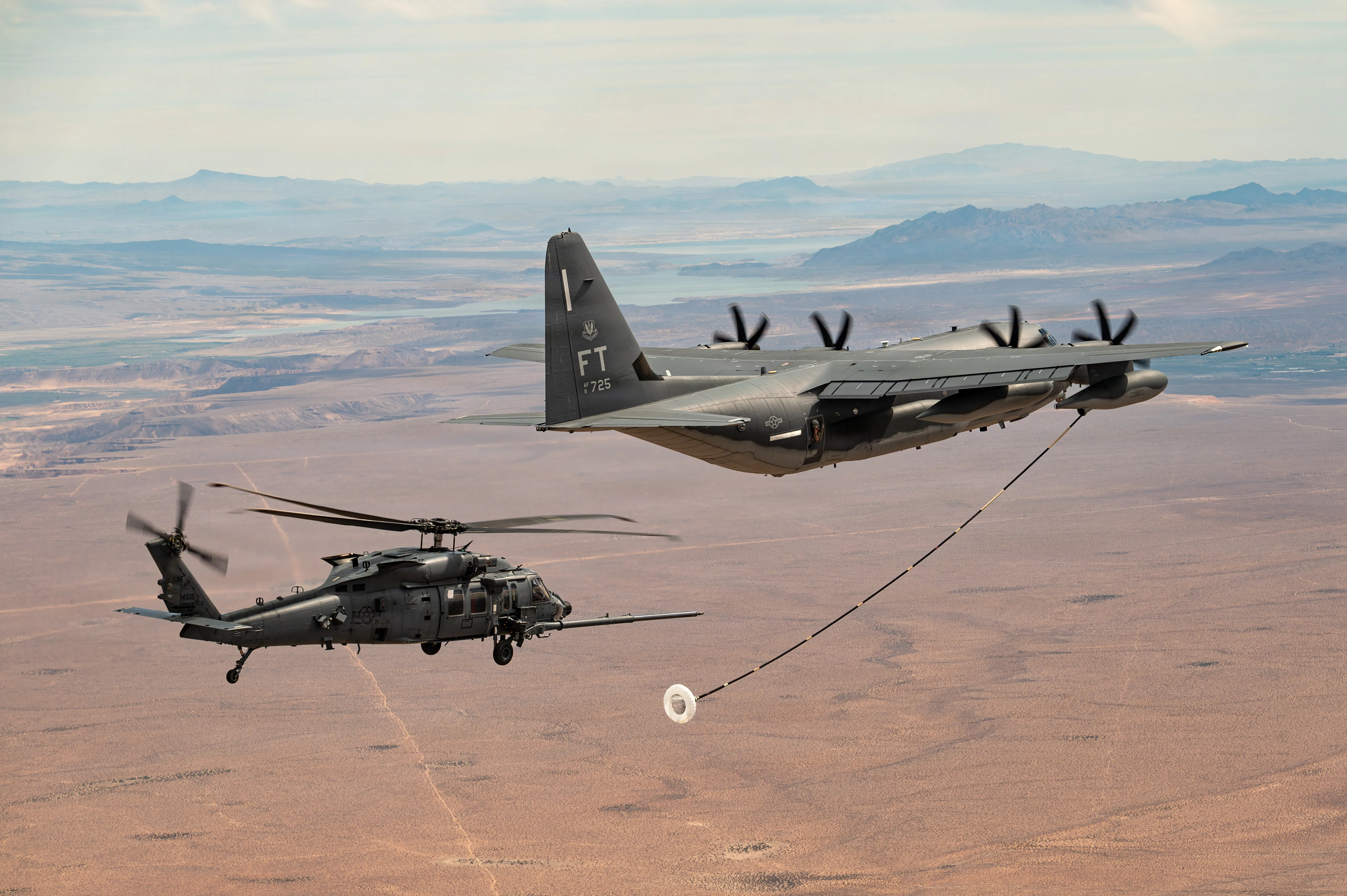 Un avion HC-130J combat King II de la US Air Force se prépare à ravitailler un hélicoptère HH-60W Jolly Green II lors d'une mission d'entraînement près de la base aérienne de Nellis, Nevada, le 24 avril 2026. L'équipage HC-130J a fourni des capacités de commandement de mission aéroportée, soutenant l'équipage HH-60W lors d'une opération de récupération du personnel au-dessus de l'eau. (Photo de l'US Air Force par Jennifer Nesbitt, membre de la 1re classe)