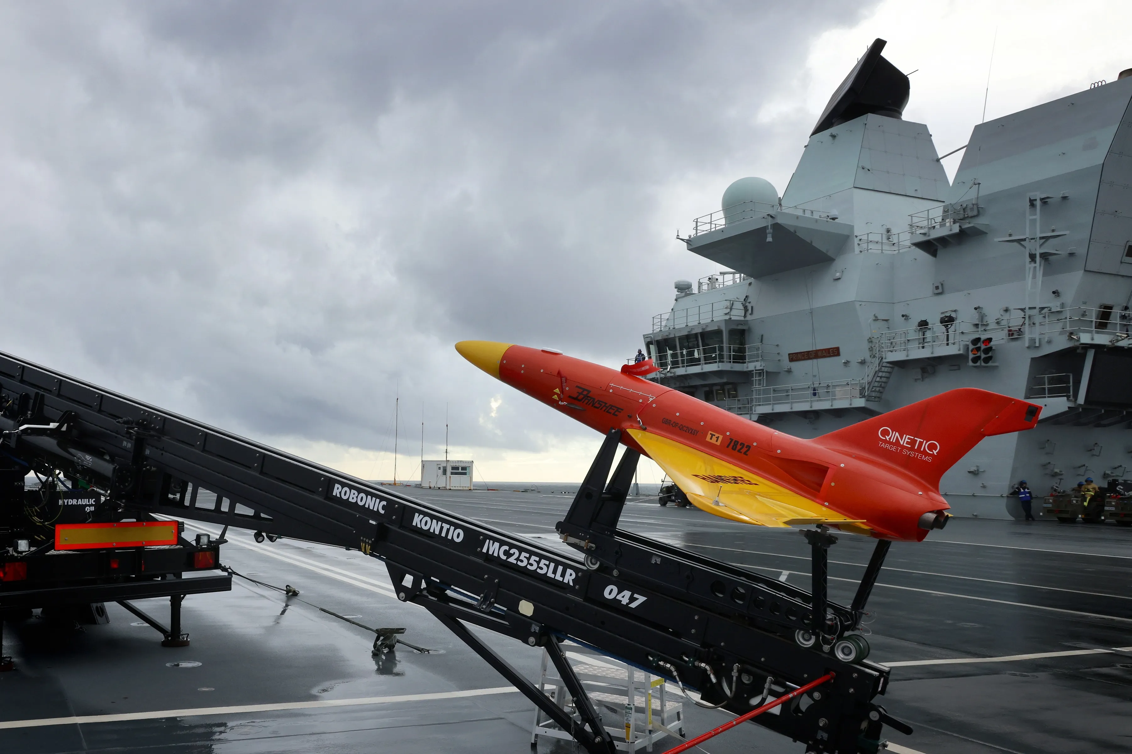 Sur la photo sur le poste de pilotage du HMS Prince of Wales se trouvent des drones cibles Banshee Jet 80 (exploités par le 847 Sqn et QuenticQ). Le HMS Prince of Wales a lancé des drones cibles depuis son poste de pilotage alors que la Royal Navy commence à explorer l'utilisation de technologies sans équipage sur les nouveaux porte-avions. Développée à partir de la cible originale Banshee, la version Banshee Jet 80 propulsée par un biréacteur a été développée en utilisant les connaissances et l'expérience acquises lors de l'exploitation de la variante à moteur monoréacteur (Banshee Jet 40) entrée en service en 2010. La version actuelle est équipée de deux moteurs à turbine à gaz de poussée de 40 kg, ce qui donne un total de 80 kg de poussée statique. Cela offre une augmentation de la vitesse maximale en ligne droite et en palier jusqu'à 180 mètres/seconde. L'utilisation d'un réservoir de carburant auxiliaire garantit une endurance similaire à celle de la version monomoteur avec un temps de mission typique à papillon mixte supérieur à 45 minutes. Lorsqu'elle est équipée du Hot Nose breveté, la cible fournit une source IR orientée vers l'avant et latérale avec une sortie dans les bandes I, II et III, tandis que les moteurs à réaction fournissent une signature IR réaliste vers l'arrière. Le HMS Prince of Wales est en mer avec des avions F35 Lightning embarqués du 207 Sqn RAF. Le porte-avions s'entraîne pour la première fois avec plusieurs F35 et continue de développer sa capacité opérationnelle alors qu'il se prépare pour son premier déploiement majeur en 2022.