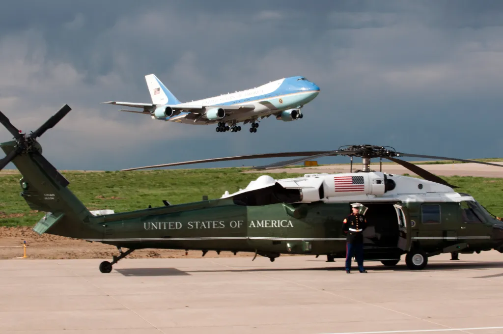 Un Marine américain se tient à l'aise à côté d'un hélicoptère de transport exécutif VH-60N Whitehawk alors qu'Air Force One atterrit à la base aérienne de Buckley, au Colorado, le 24 avril 2012. Le président Obama est en visite à l'Université du Colorado à Boulder pour parler aux étudiants d'une hausse imminente des taux d'intérêt des prêts étudiants.