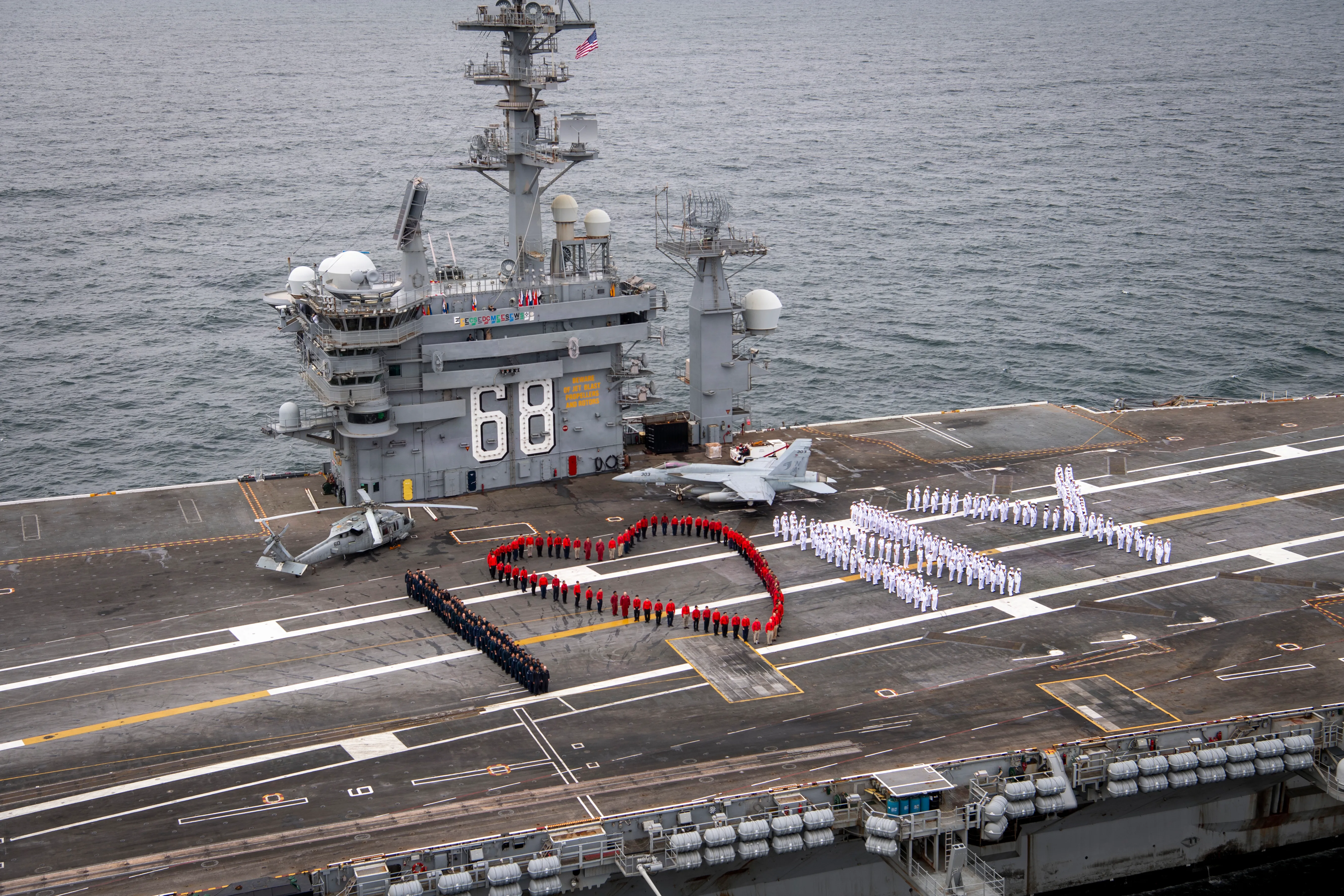 Les marins épellent « I (Heart) NY » sur le pont de vol du porte-avions de classe Nimitz USS Nimitz (CVN 68) après que le navire ait quitté le port de New York après sa participation à l'International Naval Review 250, le 7 juillet 2026. Nimitz est en cours dans la zone de responsabilité de la 2e flotte américaine dans le cadre d'un déplacement prévu du port d'attache à Norfolk, en Virginie. (Photo de l'US Navy par le matelot Alyssa Boling, spécialiste des communications de masse)