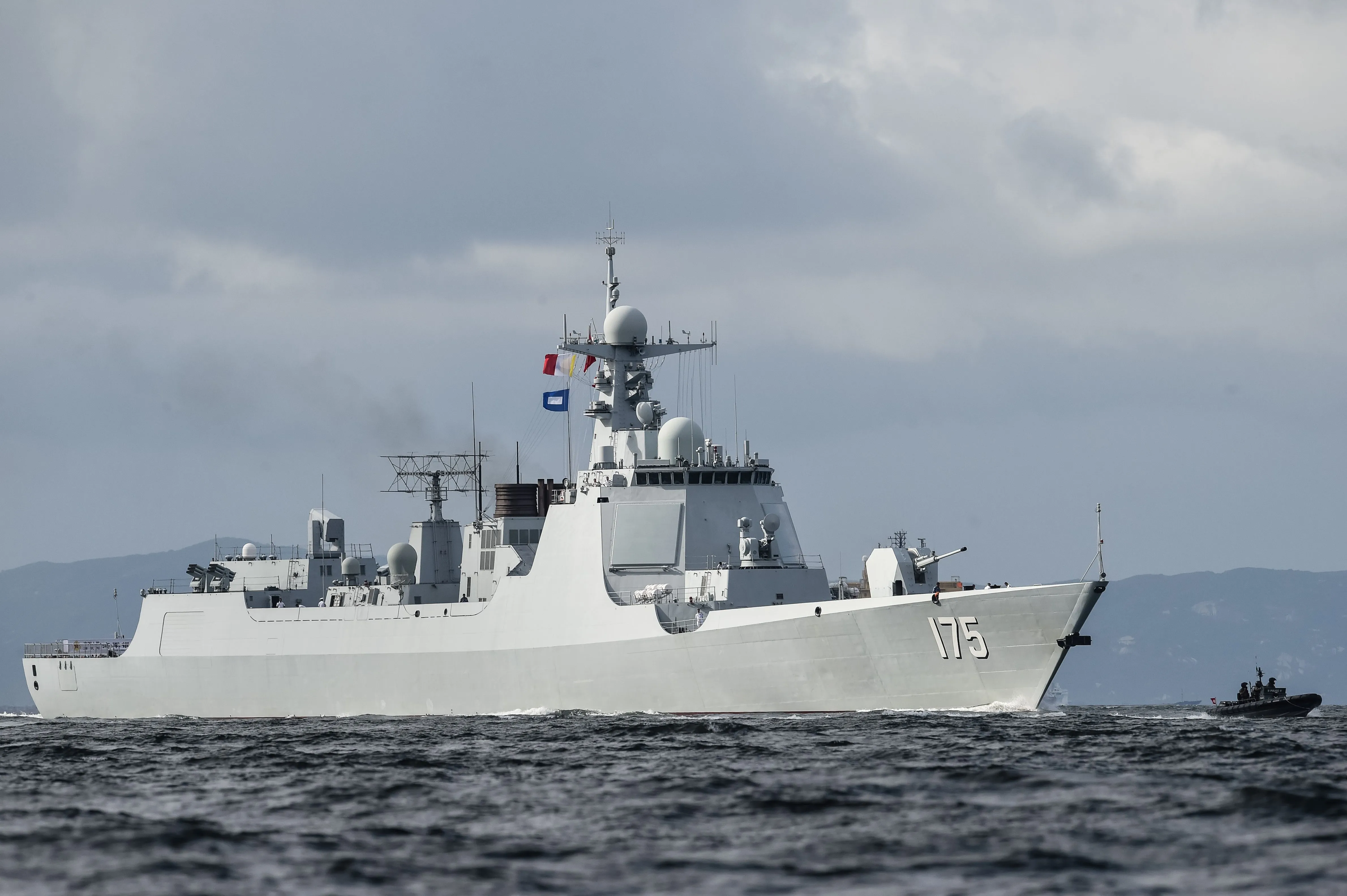 Le Yinchuan (175), un destroyer de type 052D de la marine de l'Armée populaire de libération (PLAN), fournit une escorte devant le porte-avions Liaoning dans le canal de Lamma alors qu'il arrive dans les eaux territoriales de Hong Kong le 7 juillet 2017. Le seul porte-avions opérationnel chinois est arrivé à Hong Kong pour la première fois dans une démonstration de puissance militaire moins d'une semaine après une visite très médiatisée du président Xi Jinping. / PHOTO AFP / ANTHONY WALLACE (Le crédit photo doit se lire ANTHONY WALLACE/AFP via Getty Images)
