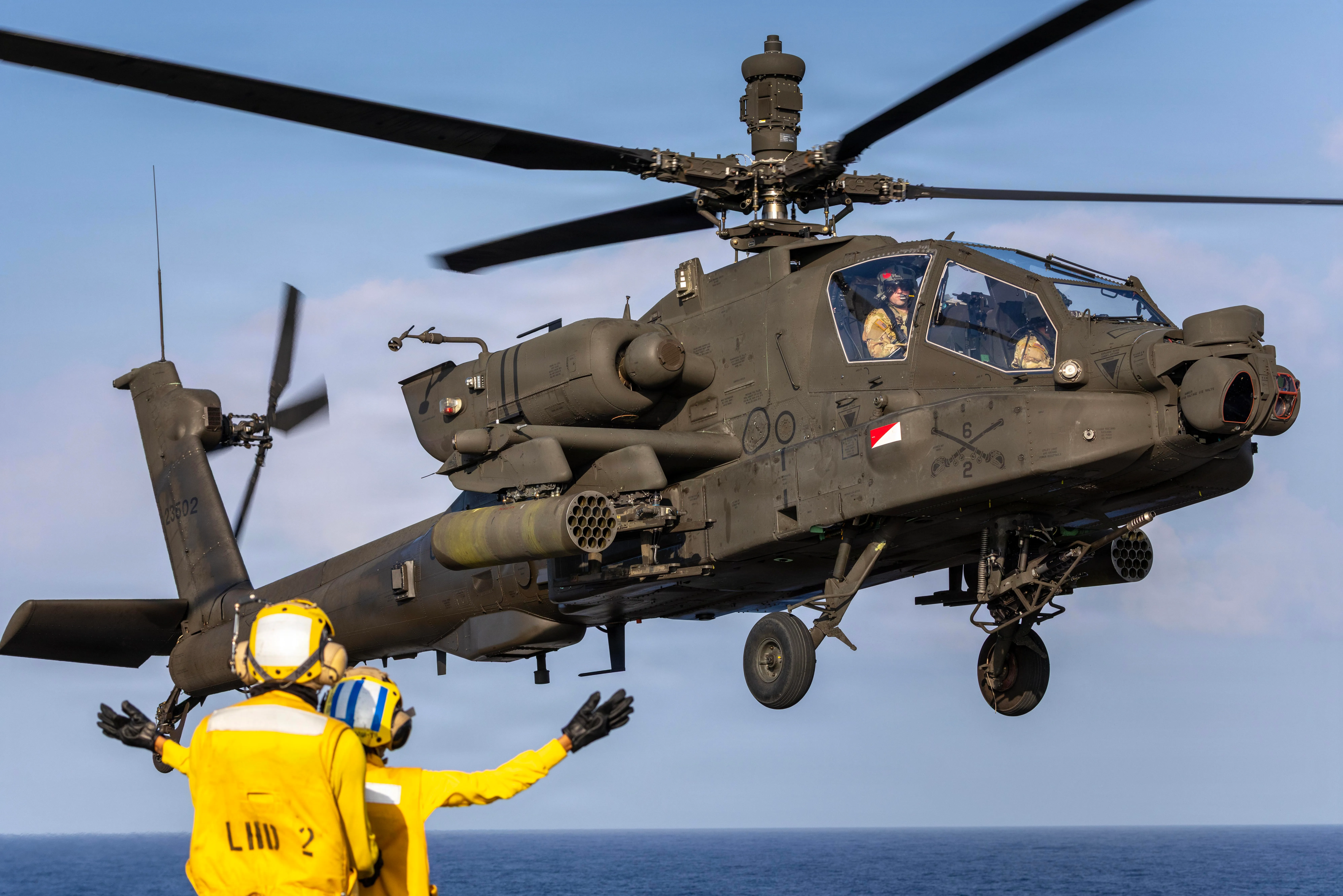 Un hélicoptère Apache AH-64 de l'armée américaine affecté à la 25e Brigade d'aviation de combat, 25e Division d'infanterie, se prépare à atterrir tout en étant dirigé par un maître de manœuvre de l'aviation de la marine américaine, affecté à l'équipe de manutention à bord du navire d'assaut amphibie de classe Wasp USS Essex (LHD 2), dans le cadre de l'exercice Rim of the Pacific 2026 dans l'océan Pacifique, le 19 juillet 2026. Trente nations, 30 navires, cinq des sous-marins, 15 forces terrestres nationales, plus de 190 aéronefs et plus de 30 000 militaires participent au RIMPAC dans et autour des îles hawaïennes, du 24 juin au 31 juillet. Le plus grand exercice maritime international au monde, RIMPAC offre une opportunité de formation unique tout en favorisant et en entretenant des relations de coopération entre les participants, essentielles pour assurer la sécurité des voies maritimes et la sécurité des océans du monde. RIMPAC 2026 est le 30e exercice de la série qui a débuté en 1971. (Photo de l'armée américaine par le Sgt. Olivia Cowart)