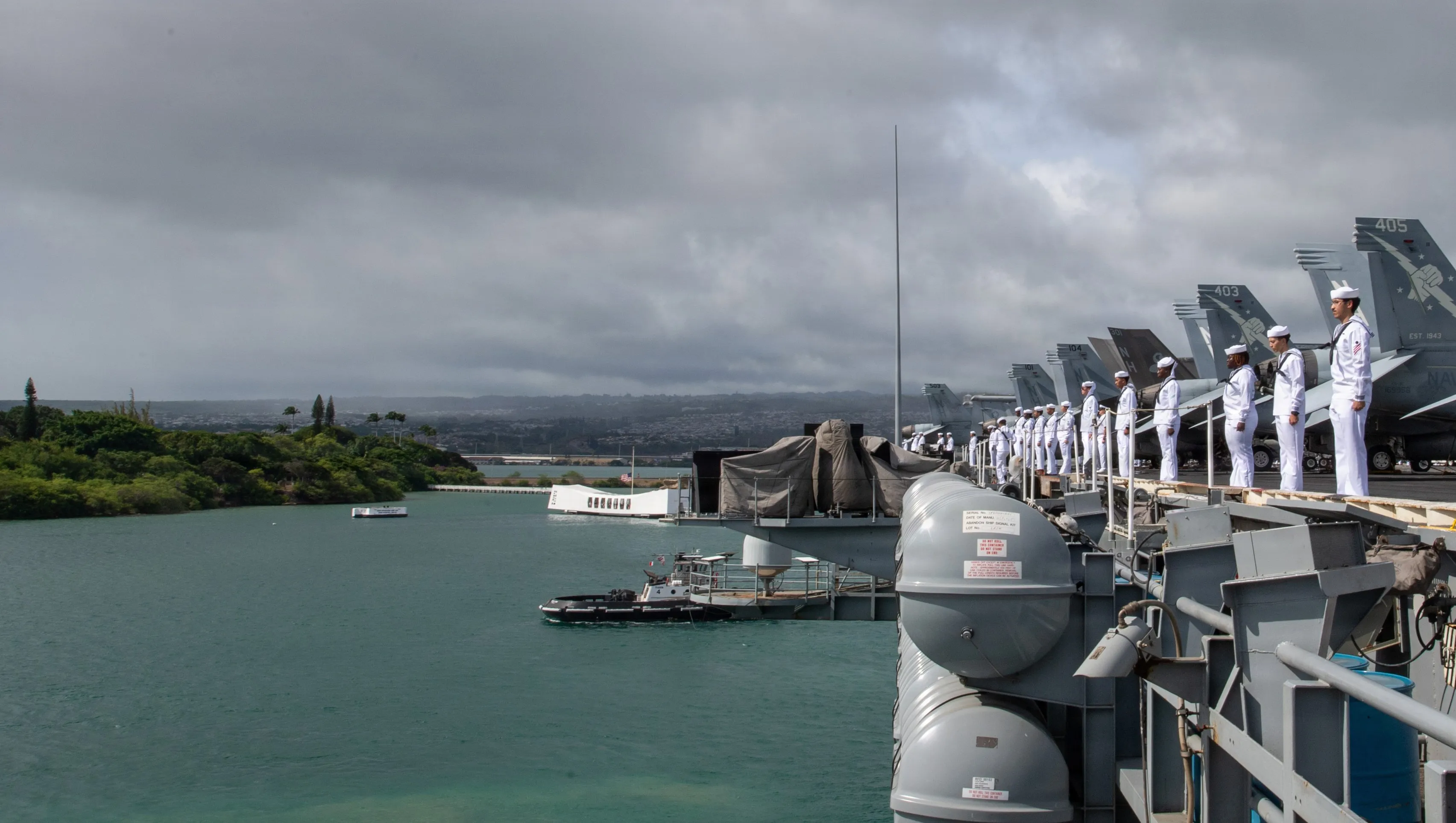 Les marins de la Marine américaine, affectés au porte-avions de classe Nimitz USS Theodore Roosevelt (CVN 71), sont sur les rails lorsque le navire passe devant le mémorial de l'USS Arizona au départ de la base commune Pearl Harbor-Hickman, le 1er août 2026. Theodore Roosevelt, vaisseau amiral du Carrier Strike Group (CSG) 9, est en cours d'exploitation dans la zone d'opérations de la 3e flotte américaine. (Photo de l'US Navy par Alexia Mezick, spécialiste des communications de masse de 3e classe)