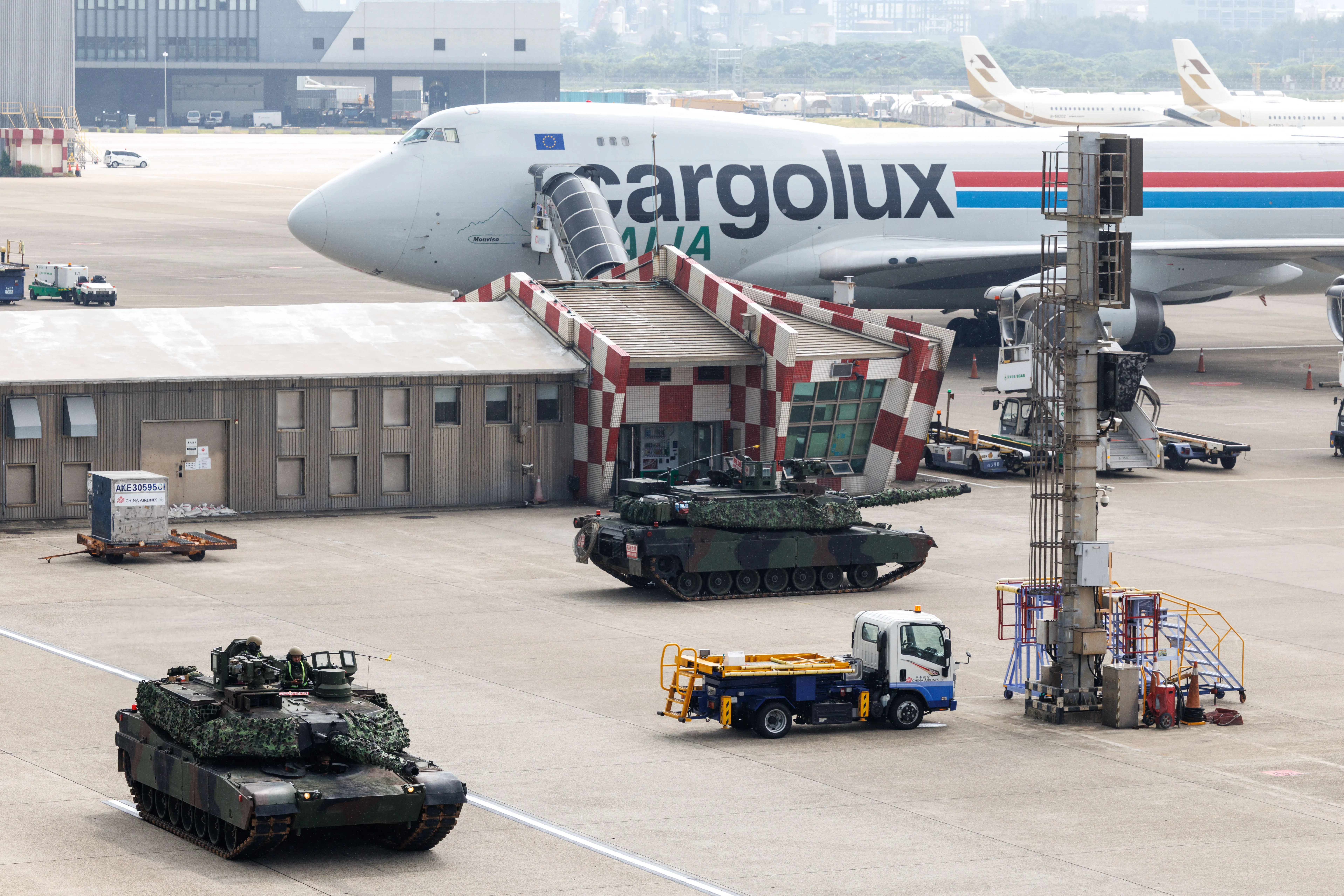 Des chars militaires taïwanais M1A2T sont photographiés à côté d'un avion lors d'un exercice simulant un assaut aérien ennemi à l'aéroport international de Taiwan Taoyuan, à Taoyuan, le 7 août 2026. Les plus grands exercices militaires de l'année à Taiwan ont commencé le 5 août alors que la démocratie insulaire tente de préparer sa population à une potentielle invasion chinoise. (Photo de CHENG Yu-chen / AFP via Getty Images)