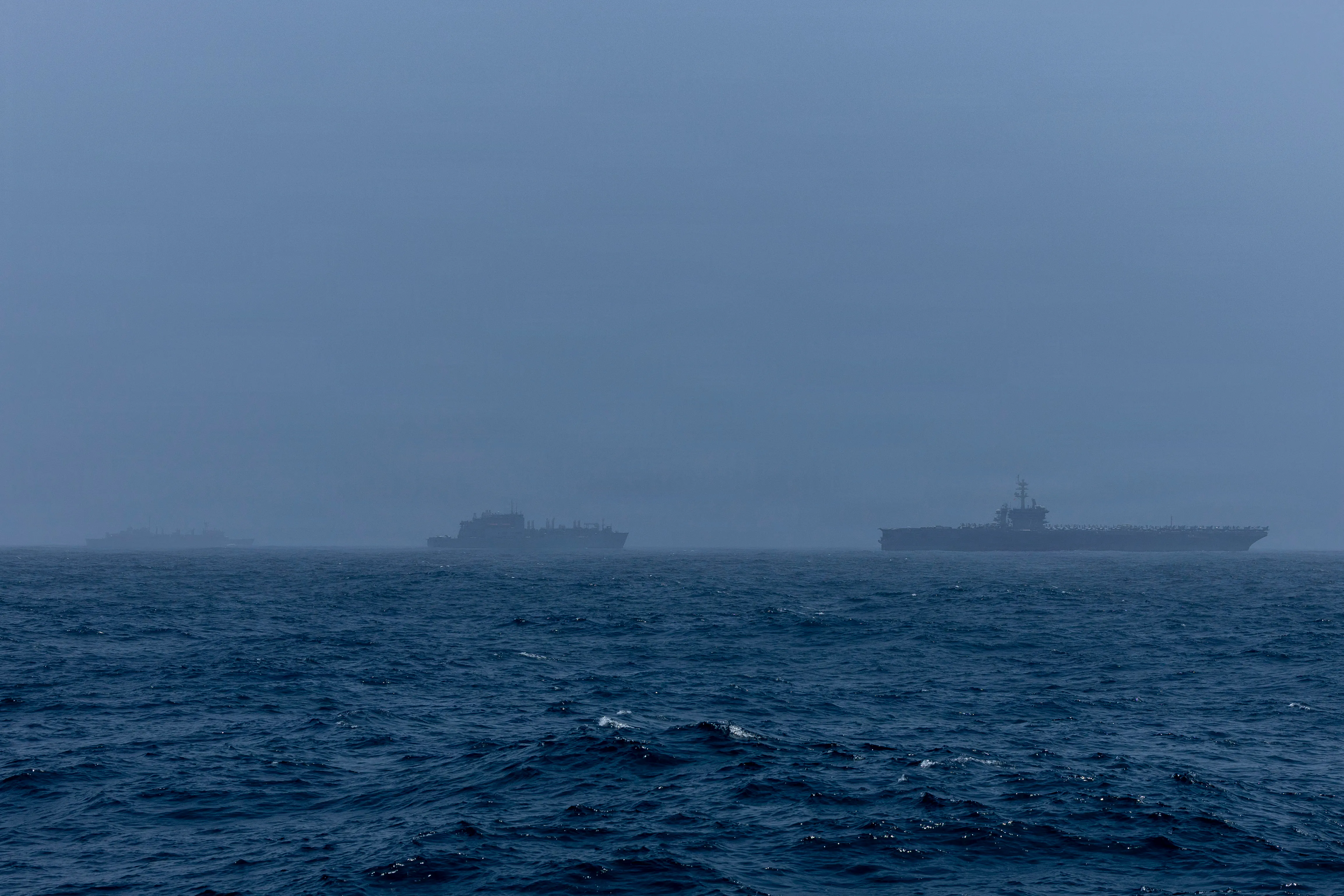 Le porte-avions de classe Nimitz USS Abraham Lincoln (CVN 72), à droite, le navire de soutien au combat rapide de classe Supply USNS Arctic (T-AOE 8), au milieu, et le cargo sec de classe Lewis et Clark USNS Alan Shepard (T-AKE-3) naviguent dans la mer d'Oman, le 16 août 2026. Abraham Lincoln est déployé dans la zone d'opérations de la 5e flotte américaine pour soutenir la sécurité et la stabilité maritimes au Moyen-Orient. (Photo de la marine américaine)