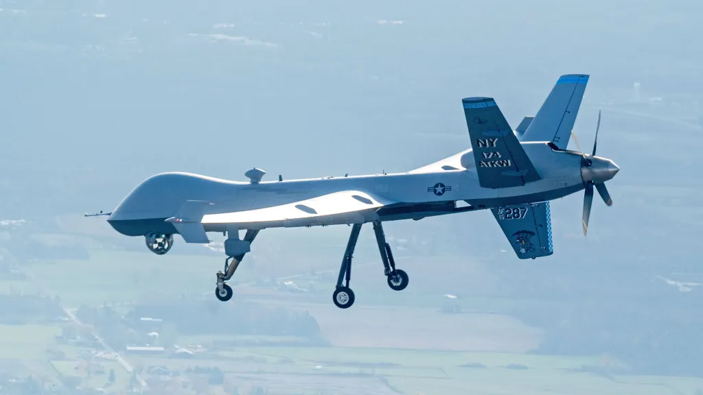 Un MQ-9 Reaper affecté à la 174e Escadre d'attaque survole la base de la Garde nationale aérienne de Hancock Field, Syracuse, NY, à la suite d'un vol d'entraînement de routine, le 31 octobre 2024. Le 108e Escadron d'attaque effectue ces vols pour instruire les pilotes et les opérateurs de capteurs sur les opérations de vol appropriées de l'avion. (Photo de la Garde nationale aérienne des États-Unis par le Senior Airman Dylan McCrink)