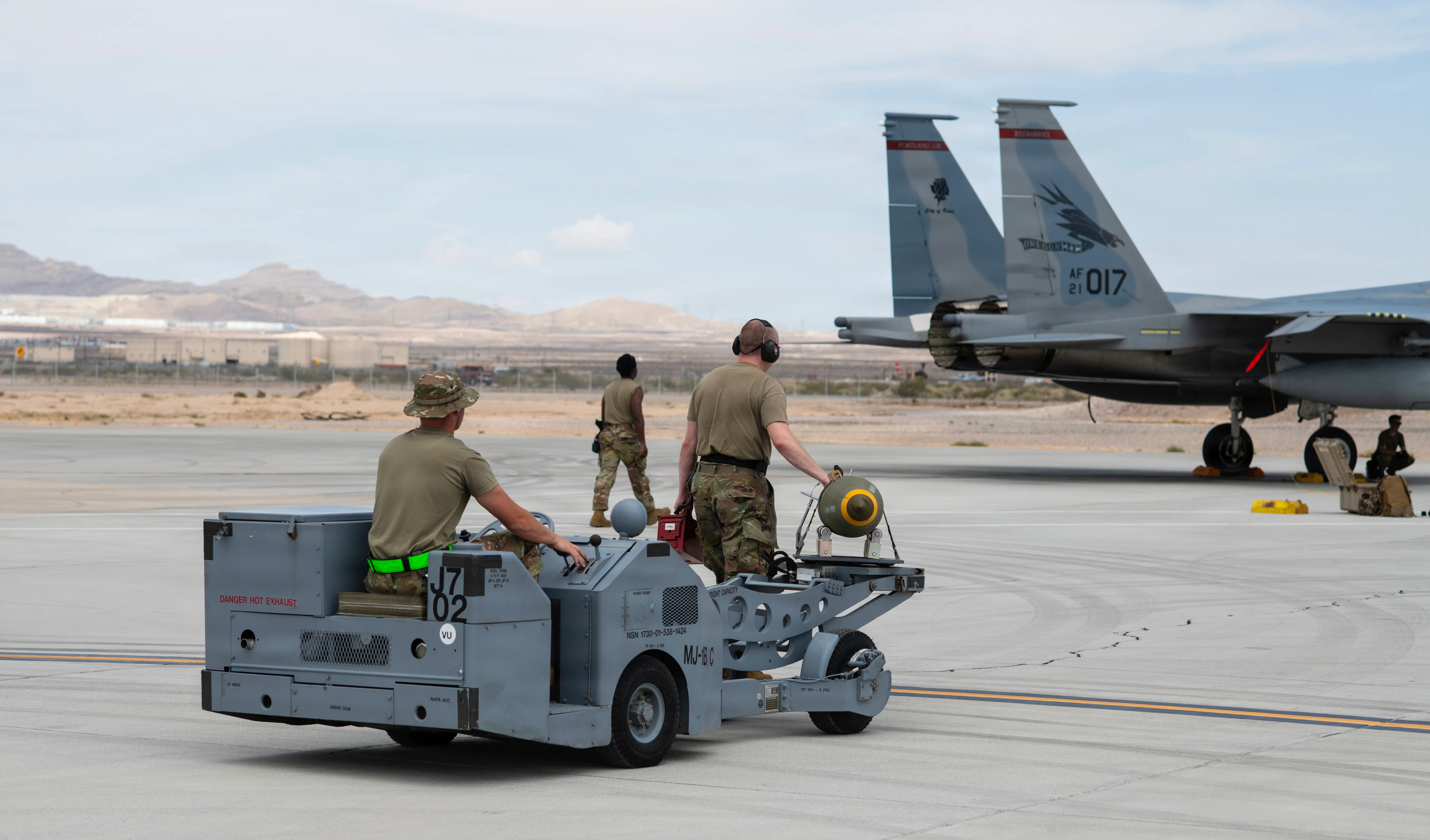 Chargeurs d'armes du 142e Escadron de maintenance des aéronefs, sergents d'état-major de l'US Air Force. Parker Mayhew (à gauche) et Eric Janson transportent une bombe vers un avion F-15EX Eagle II à l'aide d'un brouilleur, le 27 août 2026, base aérienne de Nellis (AFB), Nevada. La flotte de F-15EX de la 142e Escadre a opéré à Nellis AFB pendant trois semaines fin août et début septembre dans le cadre du cours d'instructeur d'armes (WIC) de l'US Air Force. Pendant ce temps, l'unité a franchi une étape historique en larguant pour la première fois des bombes réelles depuis des F-15EX opérationnels. (Photo de la Garde nationale aérienne des États-Unis par le sergent-chef. Steph Sawyer)