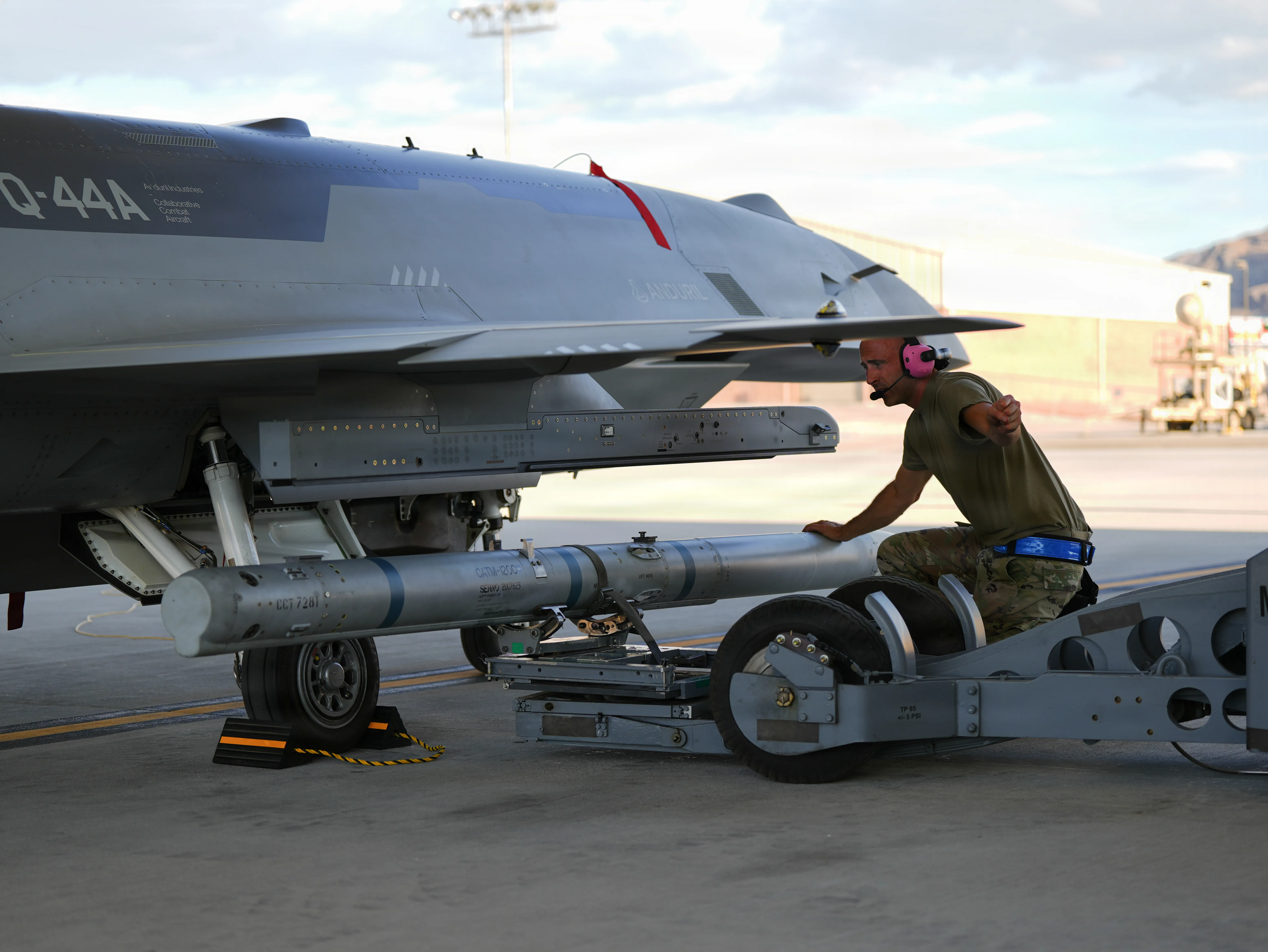 Un Airman américain affecté à l'unité d'opérations expérimentales d'avions de combat collaboratif charge un missile inerte sur un avion YFQ-44A Fury à la base aérienne de Creech, Nevada, le 20 juillet 2026. Les données de l'exercice seront utilisées pour développer et affiner de nouvelles tactiques, techniques et procédures pour les opérations aériennes semi-autonomes lorsqu'elles sont déployées à partir de bases d'opérations principales. (Photo de l'US Air Force par la Senior Airman Renee Blundon)