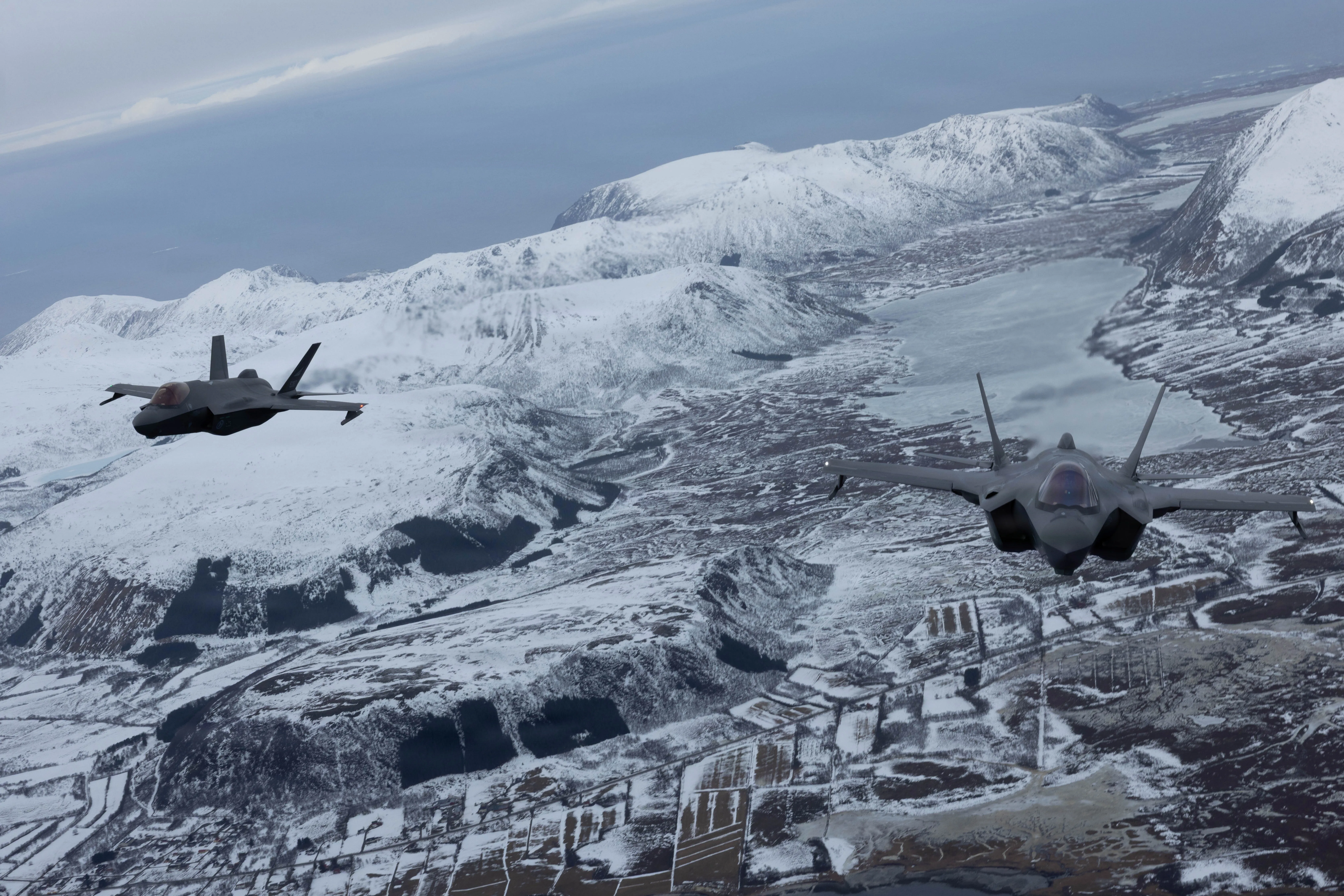 Un avion F-35A Lightning II de la 48e Escadre de chasse de l'US Air Force et de la Royal Norwegian Air Force vole en tandem après un vol de formation près de Lofoten, en Norvège, le 10 mars 2026. Le vol de formation symbolisait le partenariat et le degré d'interopérabilité affichés entre les armées de l'OTAN participantes au cours de l'exercice Cold Response 26. Élément clé de l'activité de vigilance renforcée de l'OTAN Arctic Sentry, l'exercice Cold Response 26 est un exercice militaire d'hiver dirigé par la Norvège et conçu pour renforcer les capacités de défense collective et garantir aux États-Unis être prêt à se déployer rapidement et à opérer de manière transparente aux côtés des Alliés de l’OTAN dans des conditions arctiques difficiles. (Photo du Corps des Marines des États-Unis par le Cpl. Mya Seymour)