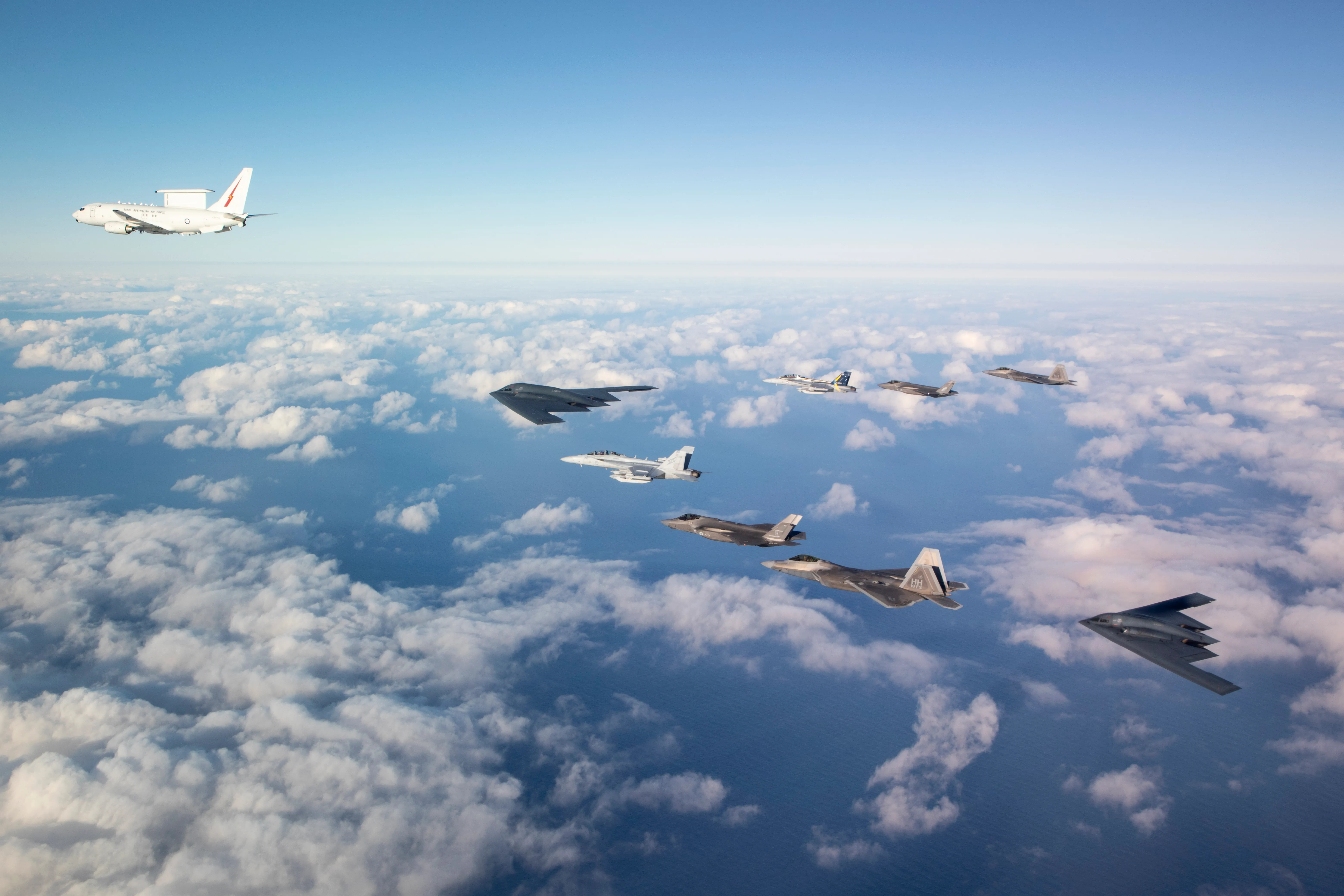 Un E-7A Wedgetail de la Royal Australian Air Force, deux avions à réaction EA-18G Growler et deux avions F-35A Lightning II volent en formation avec deux bombardiers B-2 de l'US Air Force et deux avions de combat F-22 Raptor. *** Légende locale *** Un groupe de travail sur les bombardiers composé de bombardiers furtifs B-2 Spirit de la United States Air Force, d'aviateurs et d'équipements de la 509e Bomb Wing et de la 131e Bomb Wing, opère à partir de la base de la Royal Australian Air Force (RAAF) Amberley, dans le Queensland. Ce déploiement offre à l’Australie et aux États-Unis l’occasion d’approfondir leur intégration air-air dans le cadre de la coopération aérienne renforcée. La RAAF et l’US Air Force partagent une longue histoire de liens militaires et s’entraînent régulièrement ensemble pour améliorer l’interopérabilité.