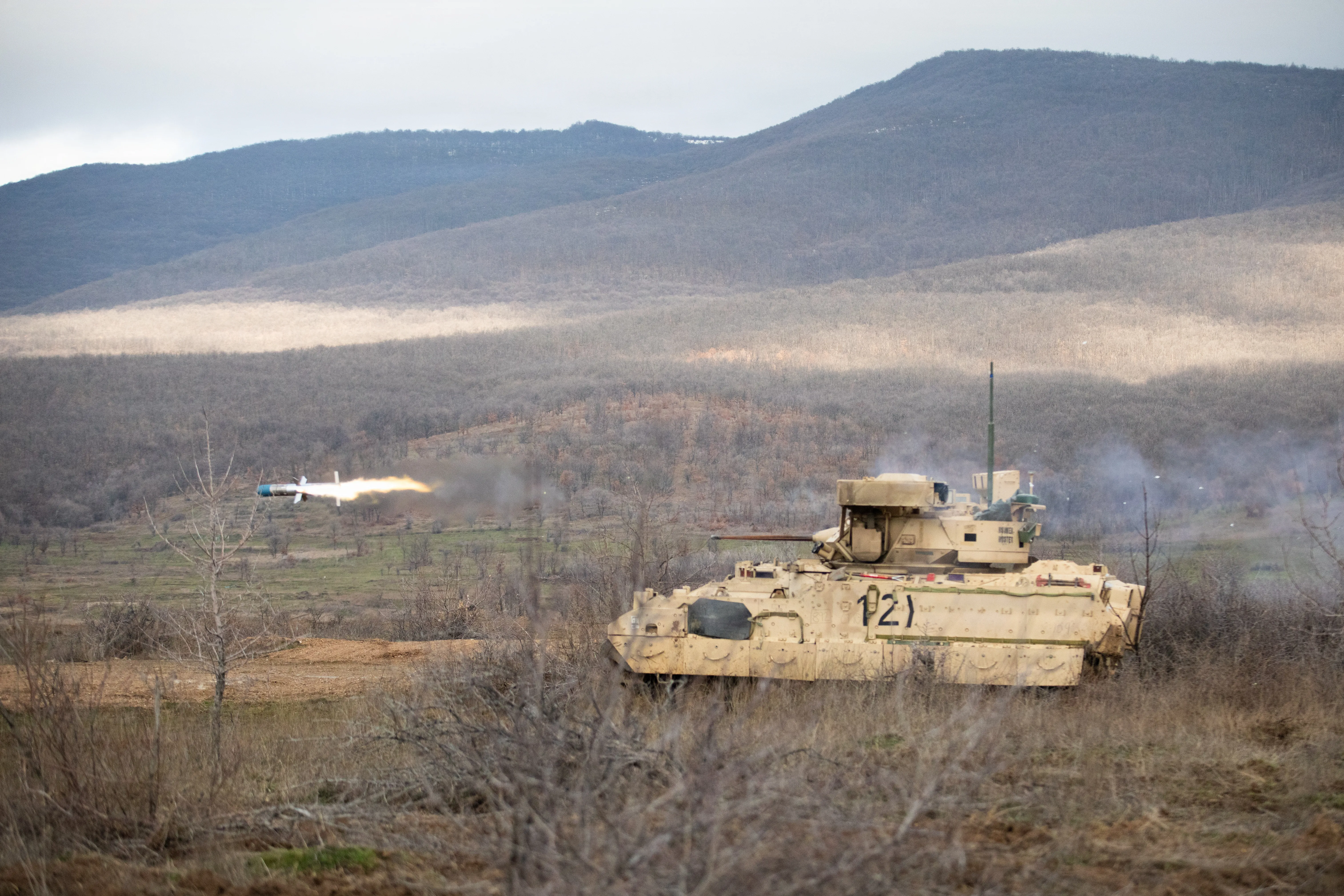 Un véhicule de combat d'infanterie M2A3 Bradley avec quartier général et compagnie de quartier général, 1er Bataillon, 16e Régiment d'infanterie, 1re équipe de combat de la Brigade blindée, 1re Division d'infanterie, utilise un lanceur à double tube monté sur tourelle pour tirer un missile antichar BGM-71 lancé par tube, à suivi optique et à guidage sans fil (TOW), le 25 février 2026, sur la zone d'entraînement de Novo Selo, en Bulgarie. La formation s'est concentrée sur le développement d'équipages individuels, les compétences d'engagement cible et la maniabilité. Les exercices de tir réel augmentent la létalité des équipages sur divers systèmes d'armes tout en générant une préparation au combat et en combattant des forces crédibles le long du flanc oriental de l'OTAN. (Photo de l'armée américaine par la CPS. Brandi Frizzell)