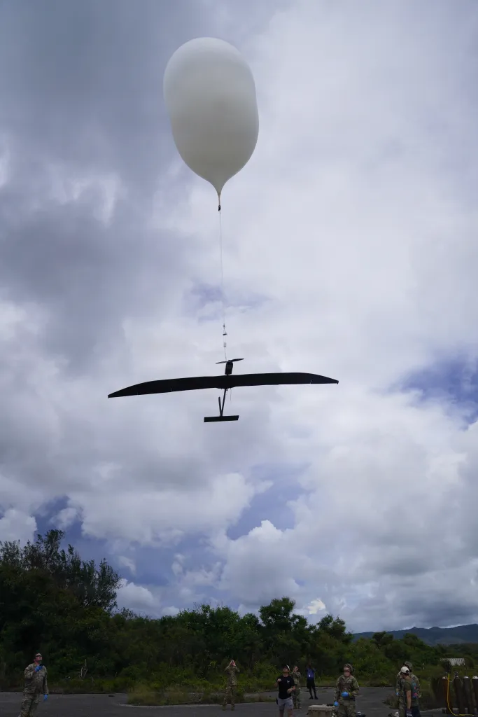 Des soldats de l'armée américaine affectés à la Extended Range Sensing and Effects Company, au 3d Multi-Domain Effects Battalion, au 3d Multi-Domain Task Force et aux partenaires industriels attachent un avion stratosphérique à voilure fixe Icarus Apollo R à un ballon à haute altitude Urban Sky lors d'une démonstration d'utilisateur spécial de plusieurs jours à l'aérodrome d'Orote sur la base navale de Guam, le 24 juin 2026, pour Valiant Shield 26. L'équipe conjointe a mené la configuration de pré-lancement pour tester des capacités de capteurs stratosphériques et des réseaux de communication étendus interarmées, faisant progresser directement notre capacité à développer et à valider des concepts de commandement et de contrôle interarmées dans tous les domaines sur le théâtre. Cette opération intermédiaire a été menée à l'appui de Valiant Shield 2026. Des exercices comme Valiant Shield permettent aux forces interarmées du Commandement du Pacifique d'intégrer les forces de toutes les branches de service et avec nos alliés pour mener des effets multi-axes et multi-domaines précis, mortels et écrasants qui démontrent la force et la polyvalence de la force interarmées et notre engagement en faveur d'un Indo-Pacifique libre et ouvert. (Photo de l'armée américaine par le Sgt. 1re classe Ondirae Hamil Abdullah-Robinson)