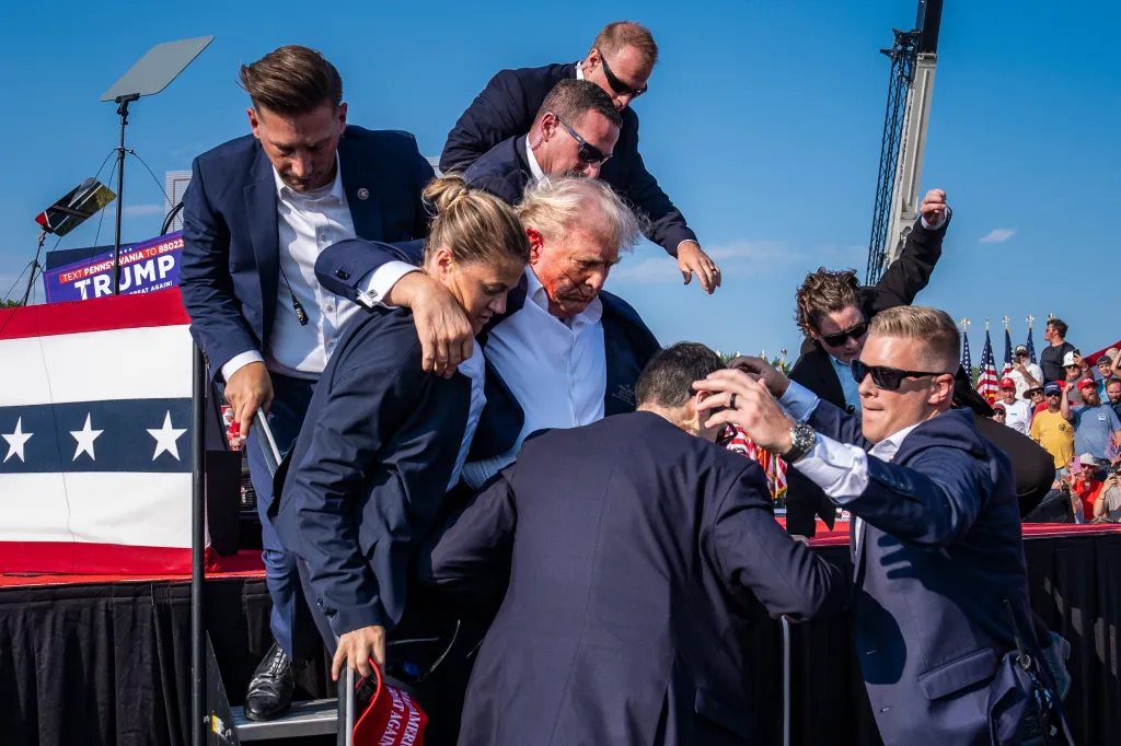 Butler, PA - 13 juillet : des agents des services secrets américains retirent de la scène le candidat républicain à la présidence, l'ancien président Donald Trump, avec du sang sur le visage, lors d'un rassemblement électoral au Butler Farm Show Inc. à Butler, en Pennsylvanie, le samedi 13 juillet 2024. Trump a déclaré plus tard qu'une balle lui avait transpercé une partie de l'oreille lors de la tentative d'assassinat. (Photo de Jabin Botsford/The Washington Post via Getty Images)